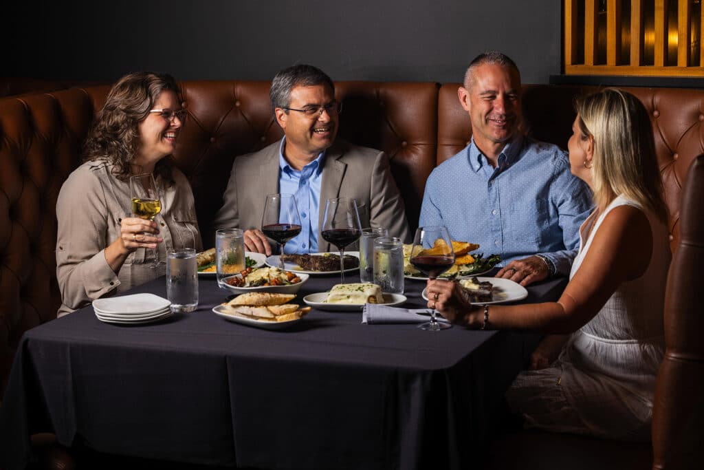 Two couples have dinner together at Bowdie's Chophouse for the holidays.