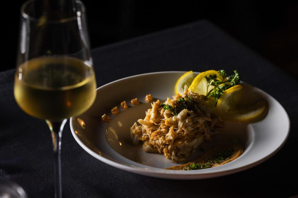 A well-plated seafood dish and a glass of white wine at Bowdie's Chophouse in Hilton Head, South Carolina.